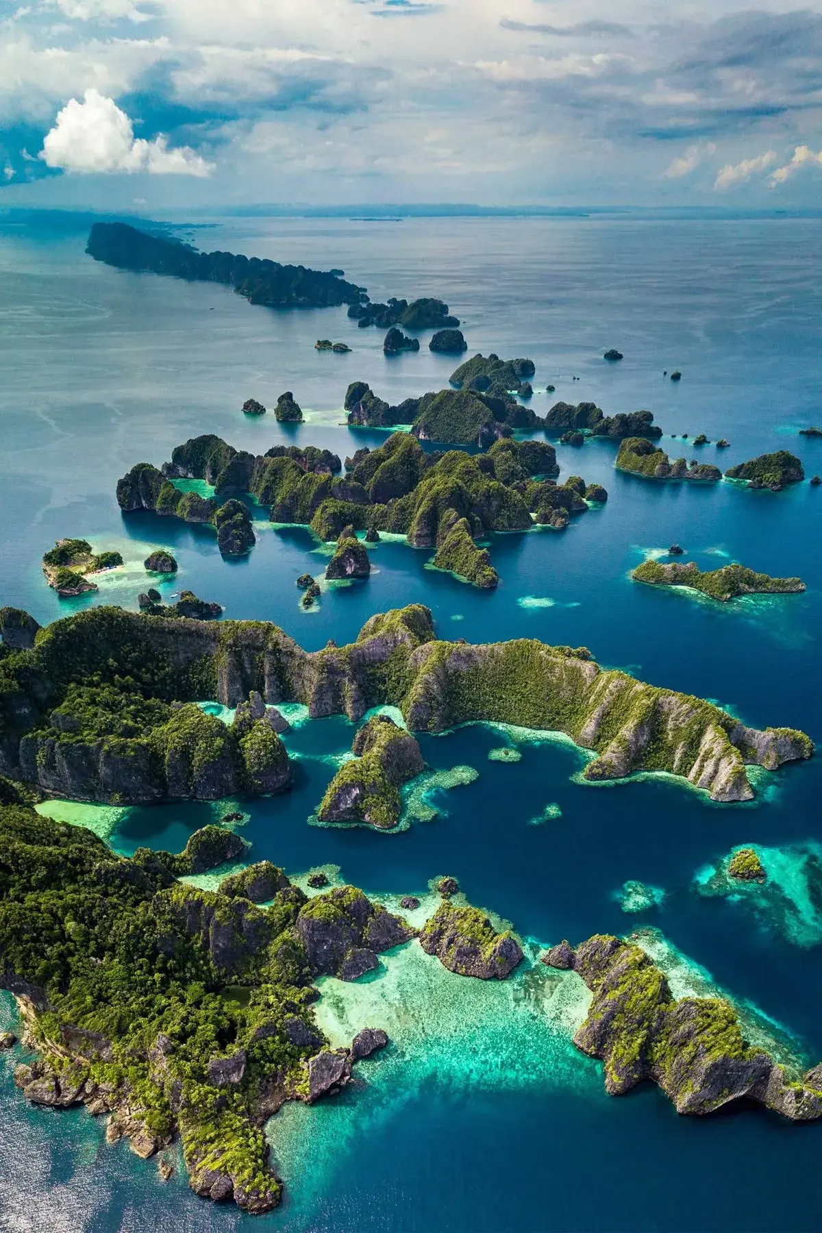 Limestone islands scattered across a turquoise lagoon, seen from the air