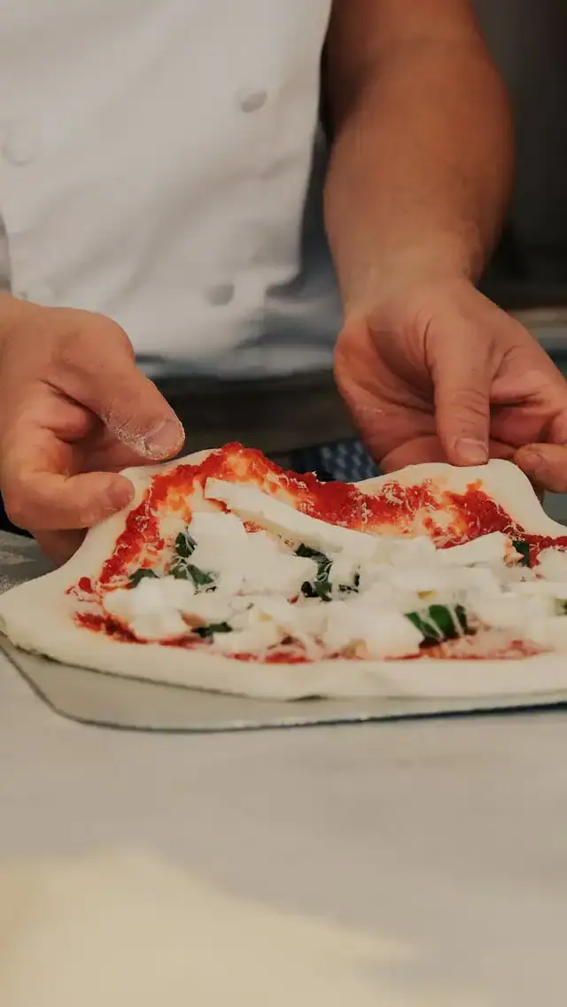 An Italian chef making pizza by hand